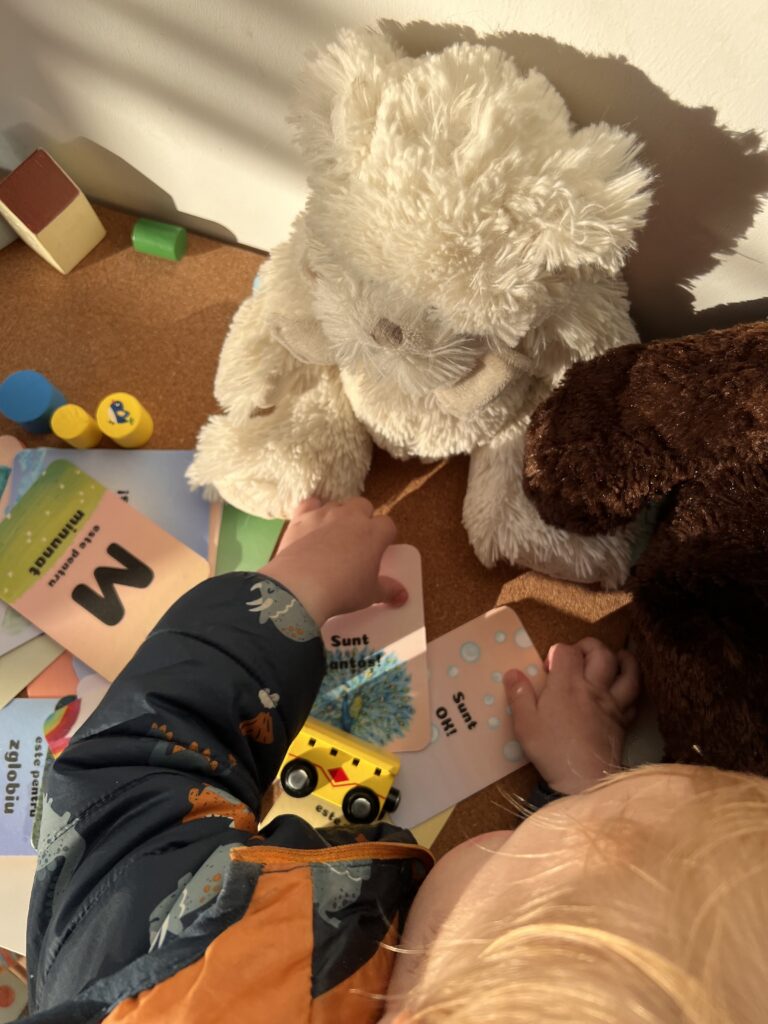 Child playing with a set of positive affirmation cards for kids and his teddy bears